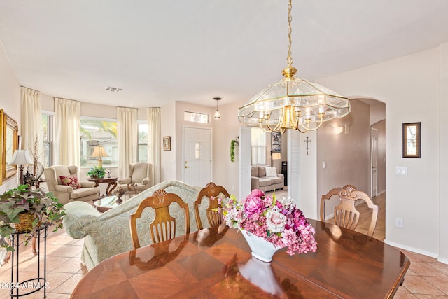 tiled dining area with a chandelier