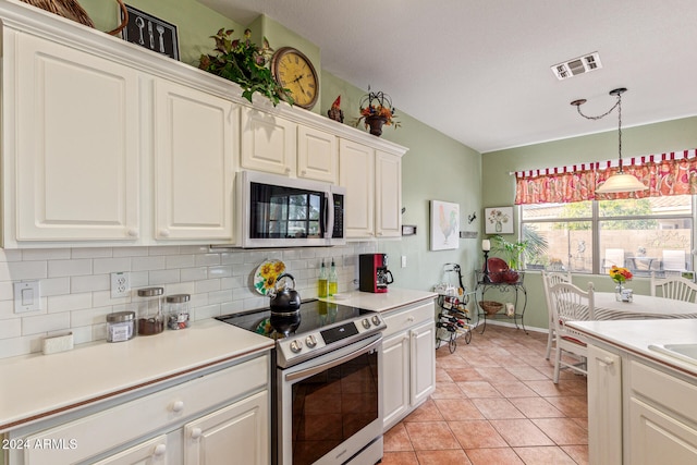 kitchen with decorative backsplash, light tile patterned floors, pendant lighting, appliances with stainless steel finishes, and white cabinetry