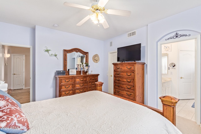 bedroom featuring ensuite bathroom, light wood-type flooring, and ceiling fan