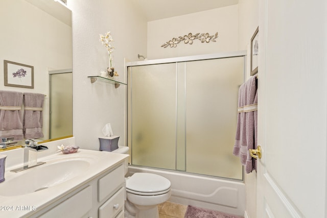 full bathroom with tile patterned floors, vanity, combined bath / shower with glass door, and toilet