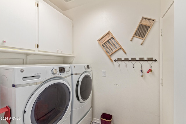 clothes washing area featuring cabinets and independent washer and dryer