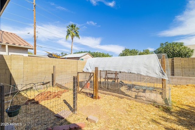 view of yard with an outbuilding, fence, and exterior structure