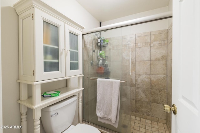 bathroom featuring a stall shower and toilet