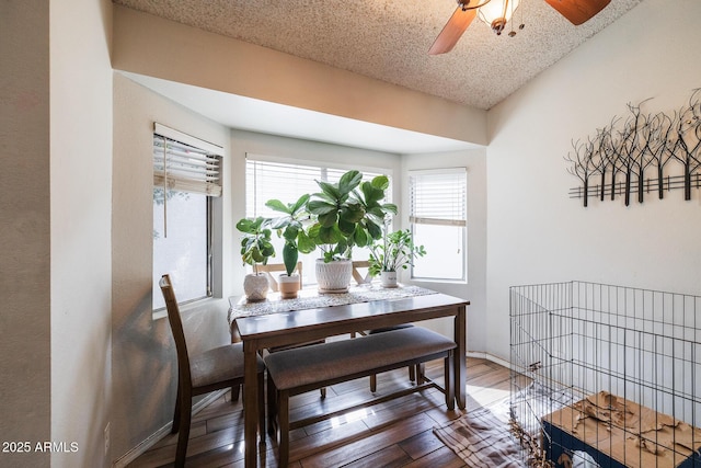 dining area with a textured ceiling, ceiling fan, hardwood / wood-style flooring, and baseboards