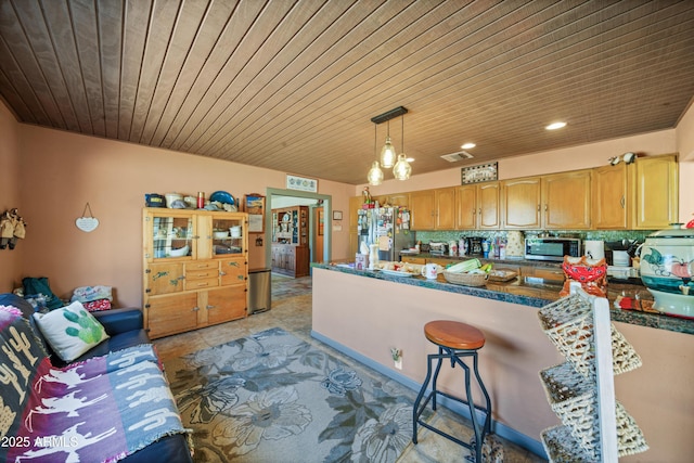 kitchen with appliances with stainless steel finishes, backsplash, pendant lighting, dark stone countertops, and a chandelier