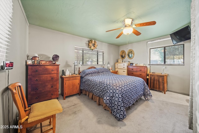 bedroom with light carpet, ceiling fan, and ornamental molding