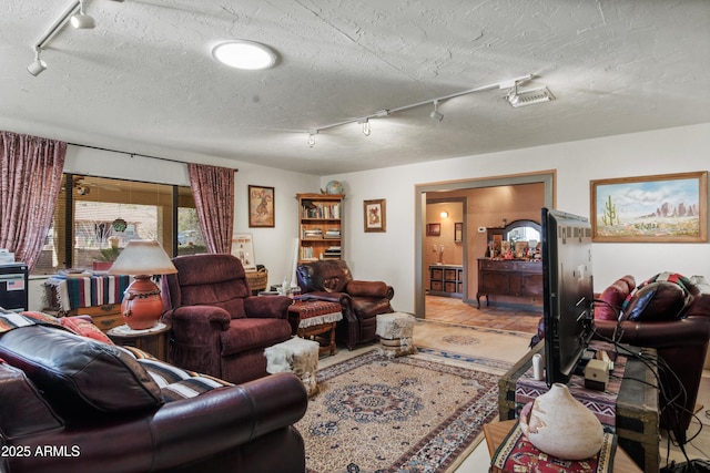 living room featuring track lighting and a textured ceiling