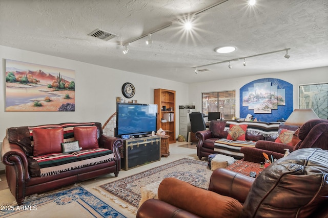 living room featuring track lighting and a textured ceiling