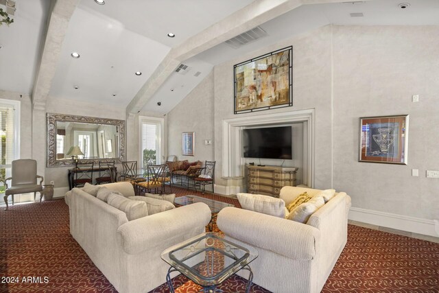 carpeted living room with high vaulted ceiling