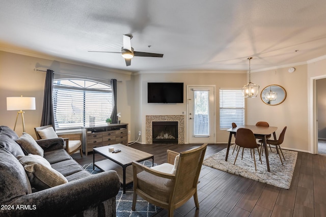 living room featuring a wealth of natural light, crown molding, and ceiling fan with notable chandelier