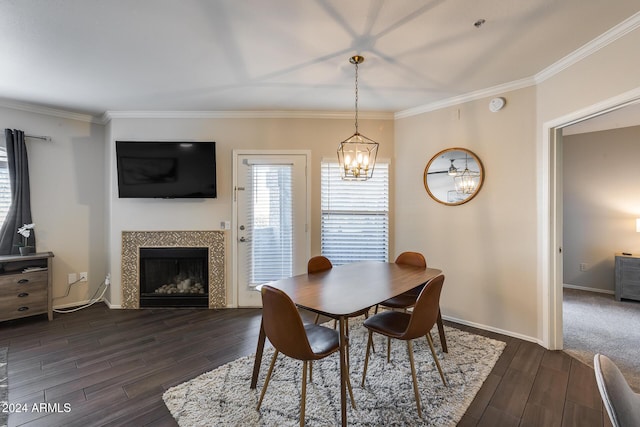 dining space with a notable chandelier, ornamental molding, and a tiled fireplace