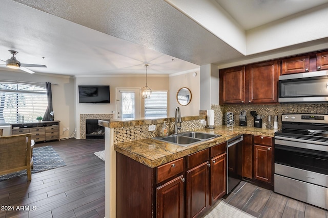 kitchen with ceiling fan with notable chandelier, sink, decorative light fixtures, kitchen peninsula, and stainless steel appliances