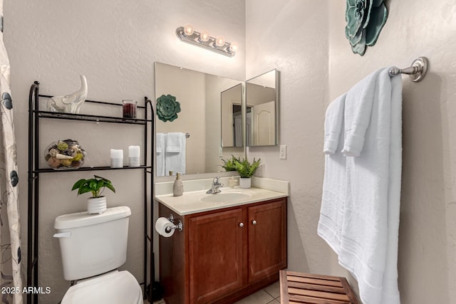 bathroom featuring tile patterned flooring, vanity, and toilet