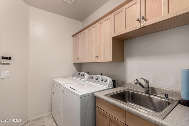 laundry room featuring light tile patterned flooring, cabinets, sink, and washing machine and dryer