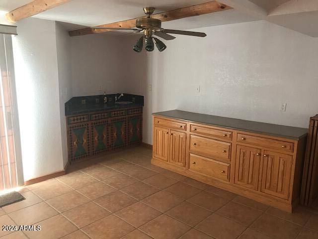 interior space featuring beam ceiling, ceiling fan, sink, and light tile patterned flooring