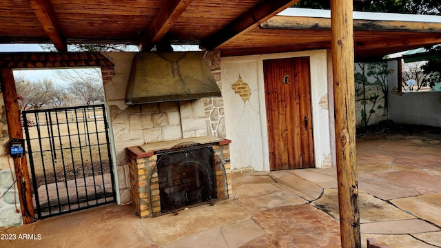 living room with beamed ceiling, an outdoor stone fireplace, and wood ceiling