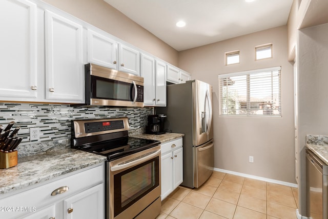 kitchen featuring backsplash, appliances with stainless steel finishes, light stone counters, and white cabinets