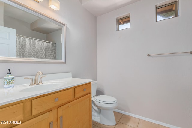 bathroom with tile floors, oversized vanity, and toilet