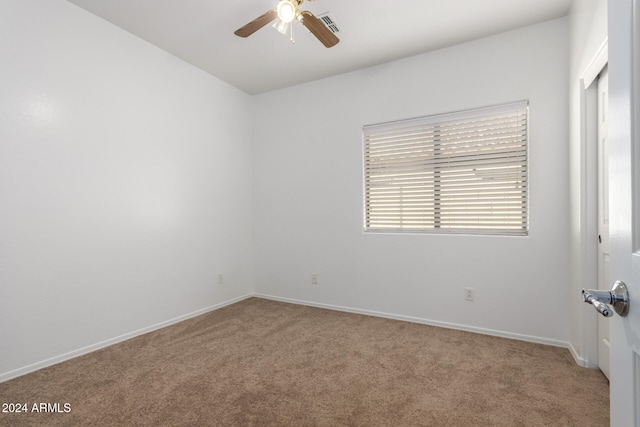 carpeted spare room featuring ceiling fan