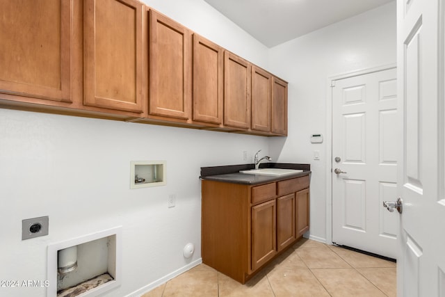 laundry area featuring hookup for an electric dryer, light tile patterned floors, cabinets, and sink