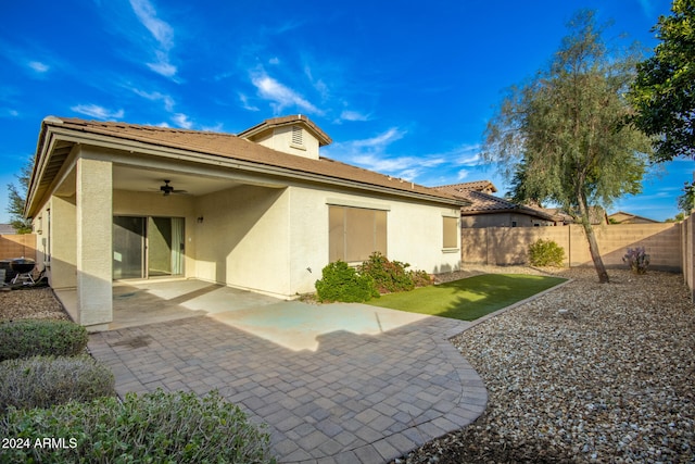 rear view of property featuring ceiling fan and a patio area