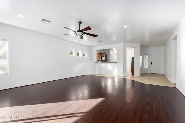 unfurnished living room featuring a wealth of natural light, light hardwood / wood-style flooring, and ceiling fan