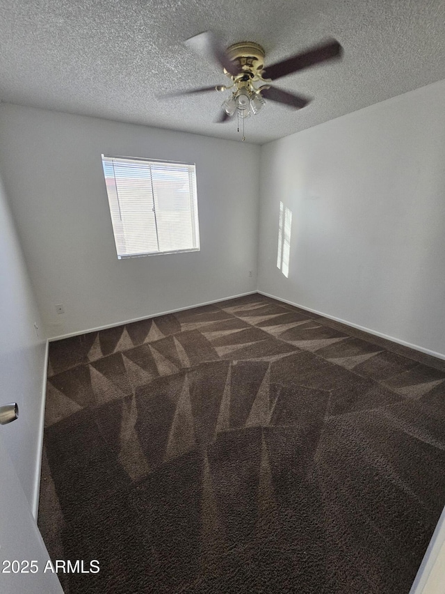 spare room with a textured ceiling, ceiling fan, carpet flooring, and baseboards