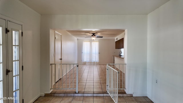 hallway with light tile patterned floors, baseboards, and french doors