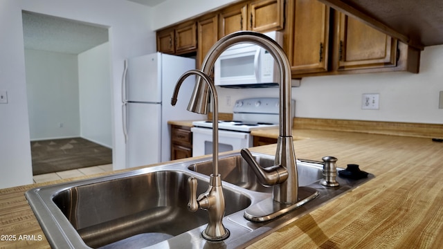 room details featuring brown cabinetry and white appliances