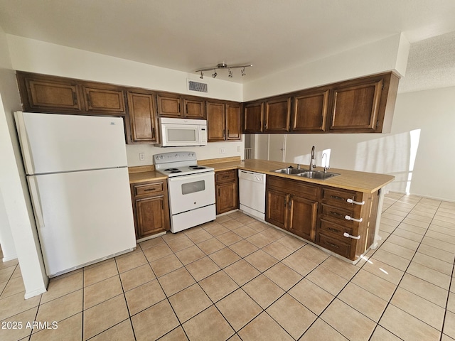 kitchen featuring light tile patterned floors, white appliances, a sink, visible vents, and light countertops