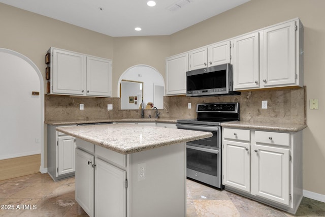11775 E Becker Ln, Scottsdale, AZ 85259 - kitchen featuring stainless steel appliances, white cabinets, a kitchen island, backsplash, and a sink