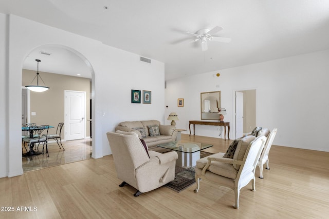 11775 E Becker Ln, Scottsdale, AZ 85259 - living room with arched walkways, a ceiling fan, and light wood finished floors