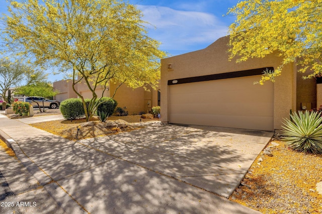 11775 E Becker Ln, Scottsdale, AZ 85259 - southwest-style home with concrete driveway, stucco siding, and an attached garage