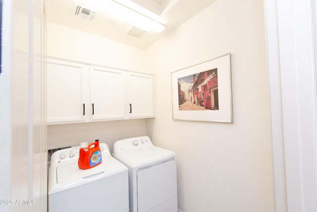 washroom featuring cabinets and independent washer and dryer