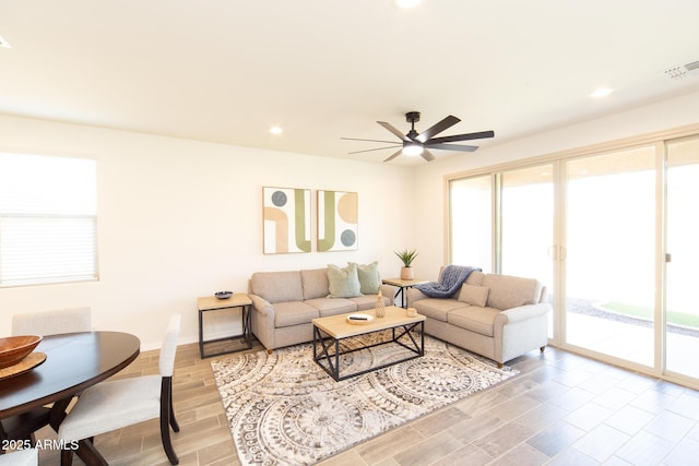 living room featuring ceiling fan and light wood-type flooring