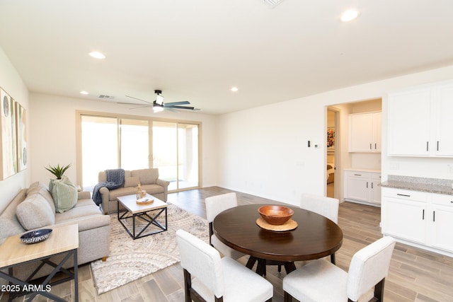 dining space with ceiling fan and light hardwood / wood-style floors