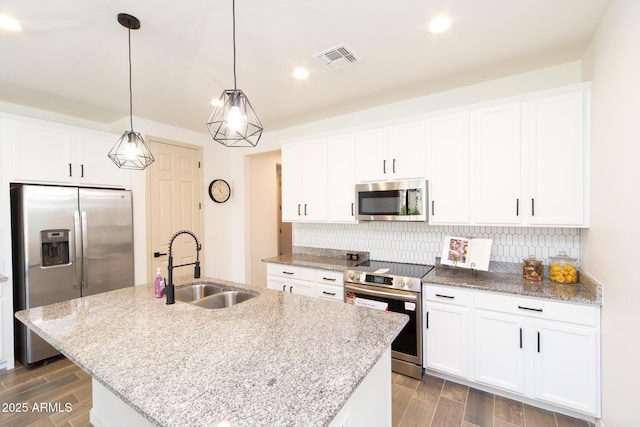 kitchen featuring white cabinetry, a center island with sink, and appliances with stainless steel finishes