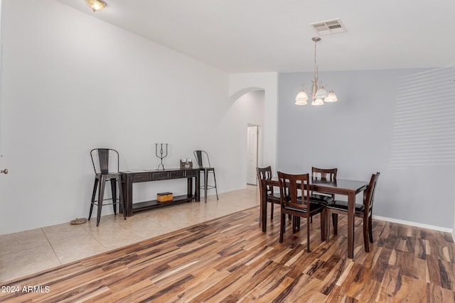 dining space with light hardwood / wood-style flooring and an inviting chandelier