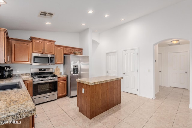 kitchen featuring sink, a center island, high vaulted ceiling, light tile patterned flooring, and appliances with stainless steel finishes