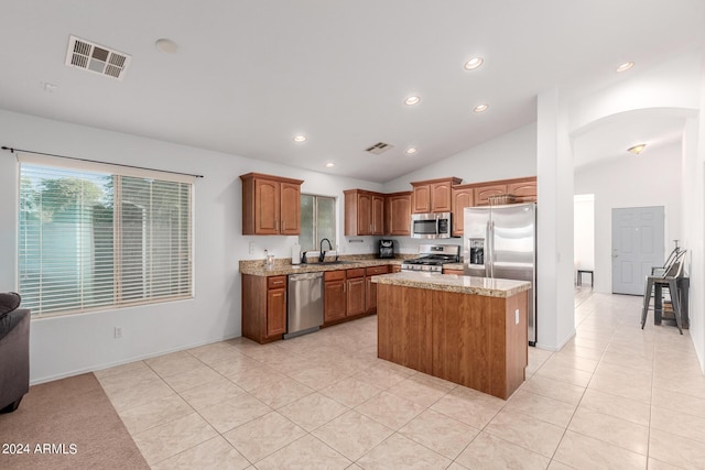 kitchen featuring a center island, lofted ceiling, sink, light tile patterned floors, and appliances with stainless steel finishes