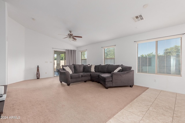 carpeted living room with ceiling fan, plenty of natural light, and vaulted ceiling