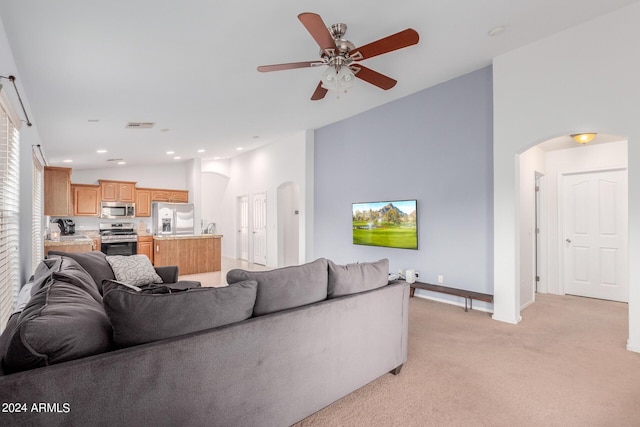 living room with light carpet, vaulted ceiling, and ceiling fan