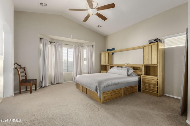 bedroom with ceiling fan, lofted ceiling, and light carpet