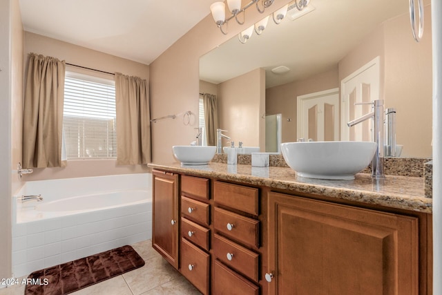 bathroom featuring tile patterned flooring, vanity, and tiled tub