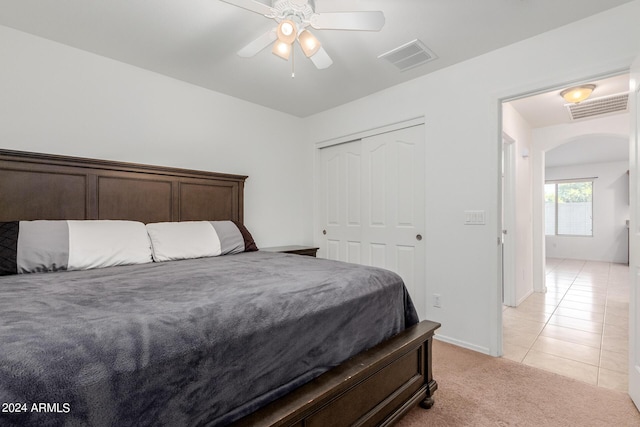 bedroom with ceiling fan, a closet, and light tile patterned flooring