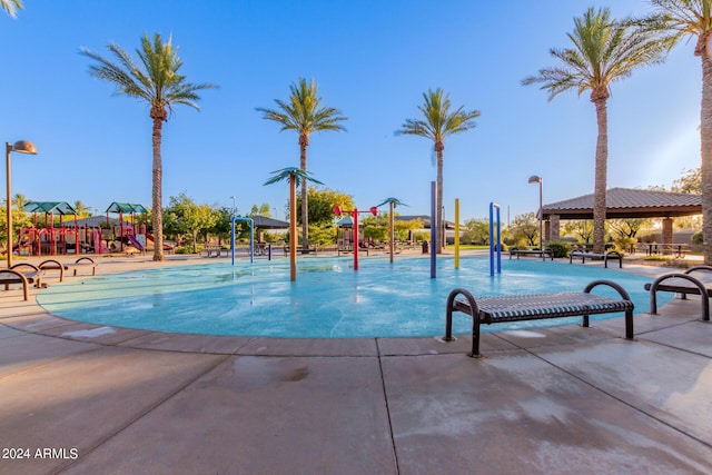 view of pool with a playground, pool water feature, and a gazebo