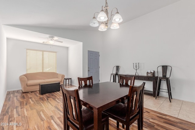 dining room featuring wood-type flooring, ceiling fan with notable chandelier, and lofted ceiling