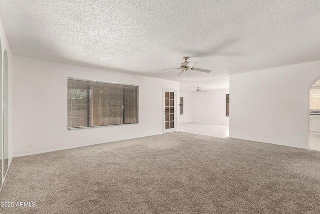 9857 W Tonto Ln, Peoria, AZ 85382 - unfurnished living room with a ceiling fan, arched walkways, carpet flooring, and a textured ceiling