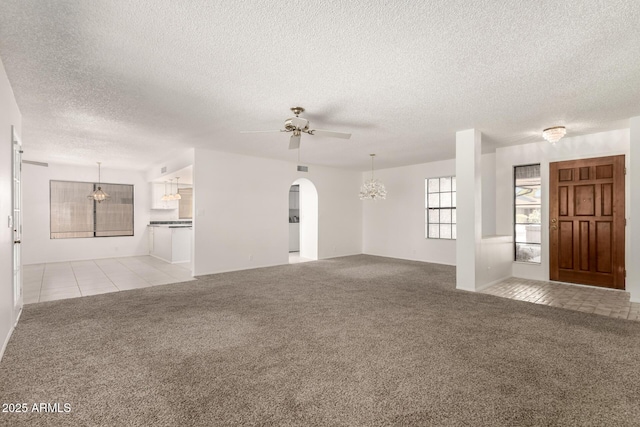 9857 W Tonto Ln, Peoria, AZ 85382 - unfurnished living room featuring light colored carpet, a textured ceiling, ceiling fan, arched walkways, and a chandelier