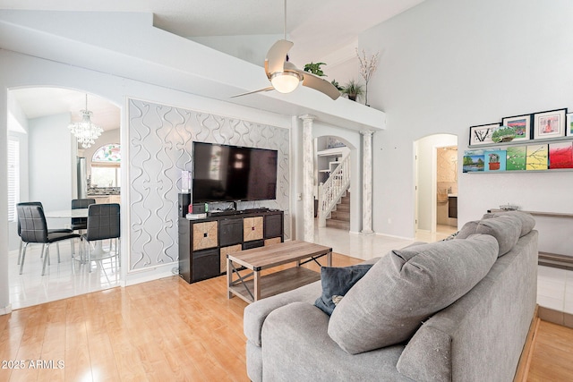 901 W Beck Ln, Phoenix, AZ 85023 - living room featuring light wood-style flooring, arched walkways, ceiling fan with notable chandelier, and stairs